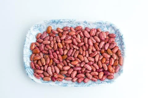 Raw dried red kidney beans served on a blue patterned ceramic plate isolate.. Stock Photos