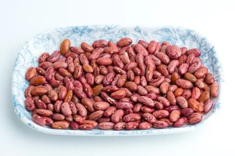 Raw dried red kidney beans served on a blue patterned ceramic plate isolate.. Stock Photos