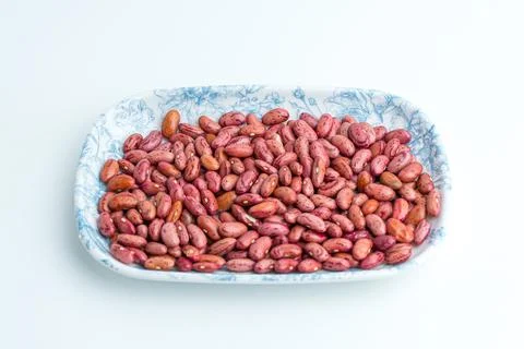 Raw dried red kidney beans served on a blue patterned ceramic plate isolate.. Stock Photos