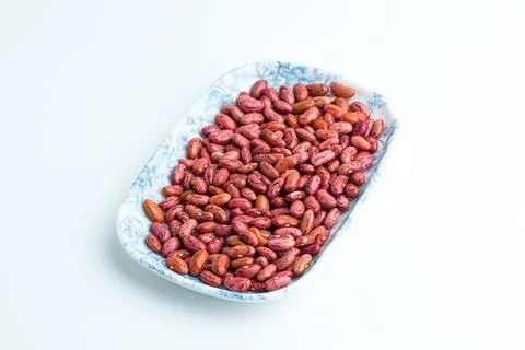 Raw dried red kidney beans served on a blue patterned ceramic plate isolate.. Stock Photos