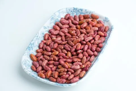 Raw dried red kidney beans served on a blue patterned ceramic plate isolate.. Stock Photos