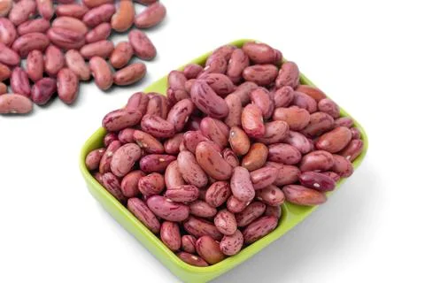 Raw dried red kidney beans in a small green rectangular dish on white backg.. Stock Photos