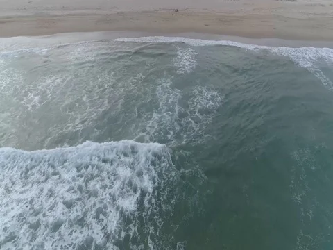 Raw drone shot of flying behind waves moving towards the shore 스톡 동영상 75805901