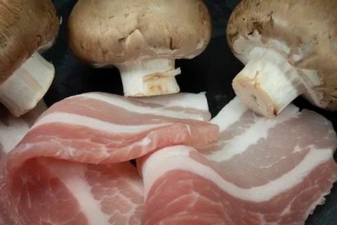 Raw dry-cured back bacon and mushrooms Stock Photos