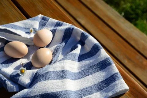 Raw duck eggs with napkin on wooden table outdoors. Space for text Stock Photos