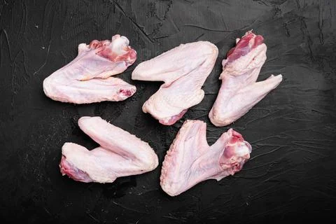 Raw duck wings, on black dark stone table background, top view flat lay Foto stock