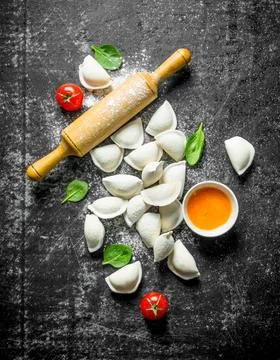 Raw dumpling with cherry tomatoes and spinach leaves. Stock Photos