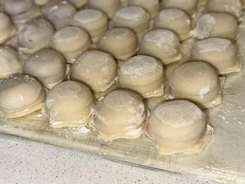 Raw Dumplings on Floured Surface Stock Photos