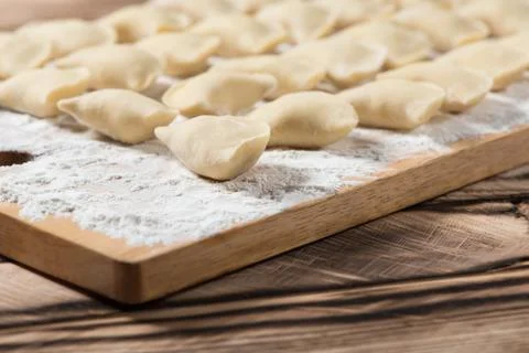 Raw dumplings on wooden cutting board, is ready to boil. Also known as Vareni Stock Photos