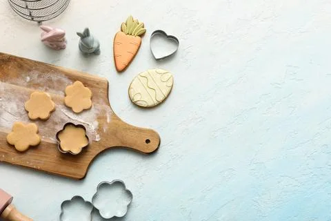 Raw Easter cookies with kitchen utensils on light blue background Stock Photos