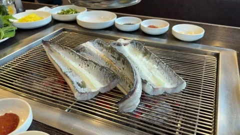 Raw Eel Cooking on Charcoal Grill at Korean Restaurant Stock Footage 337548409