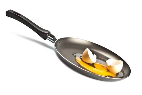 Raw egg and shell on black pan Stock Photos