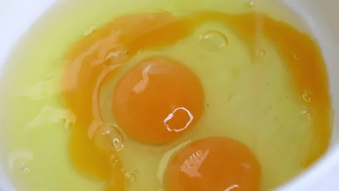 Raw egg is broken into a bowl close-up, the process of preparing breakfast Stock Footage 162118772