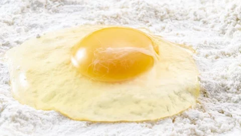 Raw egg cracked onto flour, baking preparation, zoom pan Stock Footage 337671036