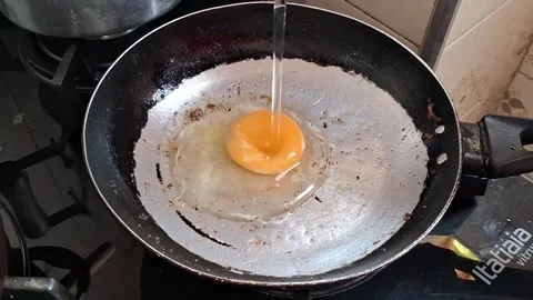 Raw egg cracking into hot frying pan kitchen cooking video footage Stock Footage 339374504