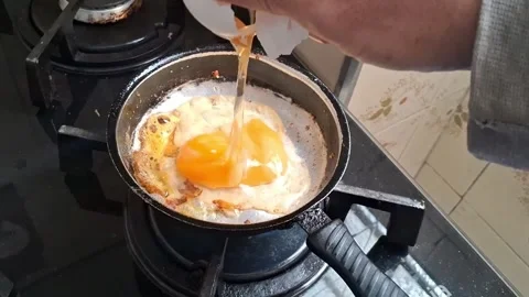 Raw egg cracking into hot frying pan Stock Footage 345843457