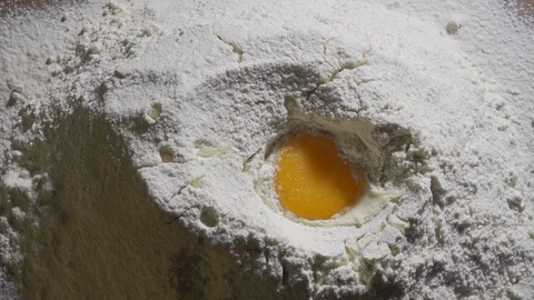 Raw egg dropped into flour in slow motion Stock Footage 127854957
