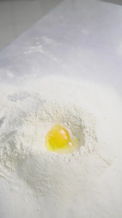 Raw Egg Falling Into Flour Well for Traditional Dough Making Vídeos de archivo 341417537