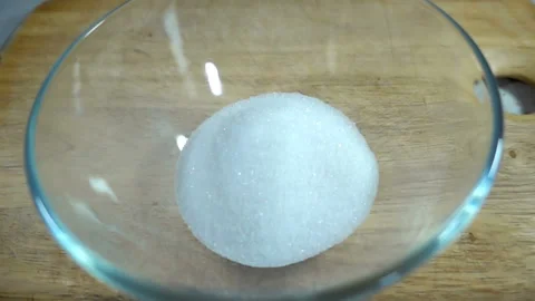 A raw egg falls in slow motion onto a sugar hill Stock Footage 131807428