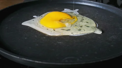 Raw egg falls onto the surface of a hot frying pan in slow motion, close-up 스톡 동영상 263022890