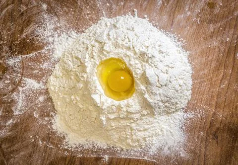 Raw egg in flour Stock Photos