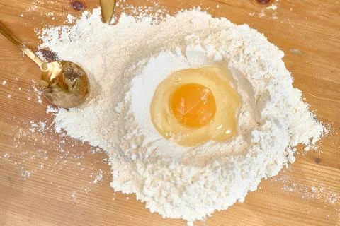 Raw Egg in Flour Well for Making Homemade Dough on Wooden Table Stock Photos