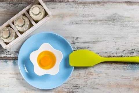 Raw egg on a rustic table top with kitchen utensils Stock Photos