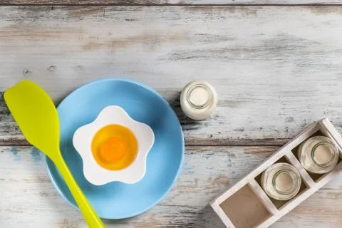 Raw egg on a rustic table top with kitchen utensils Stock Photos