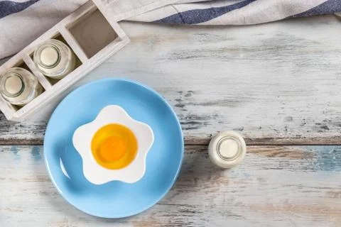 Raw egg on a rustic table top with kitchen utensils Stock Photos