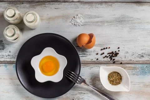 Raw egg on a rustic table top with kitchen utensils Stock Photos
