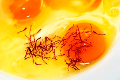 Raw egg with saffron Stock Photos