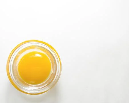 Raw egg without shell on a white background. Stock Photos