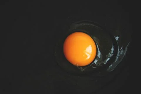 Raw egg with yellow egg broken into a frying pan Stock Photos