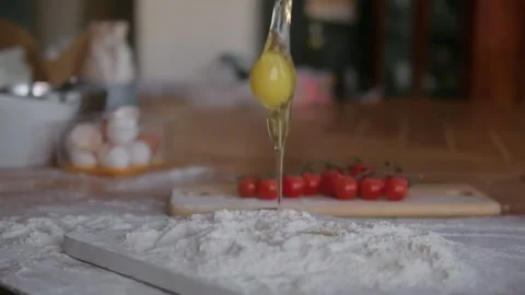 Raw Egg Yolk Falling into Pile of Flour Making Hole. Slow motion of falling eggs Stock Footage 260901855