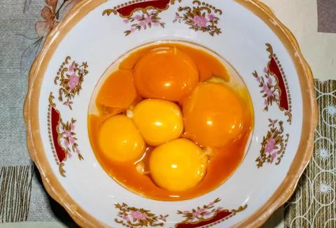 Raw egg yolks separated from egg whites in a plate. Foto stock