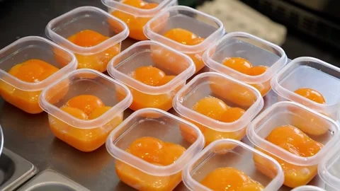 Raw Egg Yolks in Small Transparent Plastic Containers Stock Footage 331772572