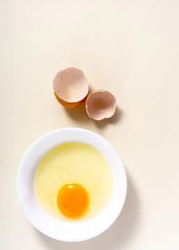 Raw eggs and egg shell in a glass bowl on the table. Top View. Broken White.. Stock Photos