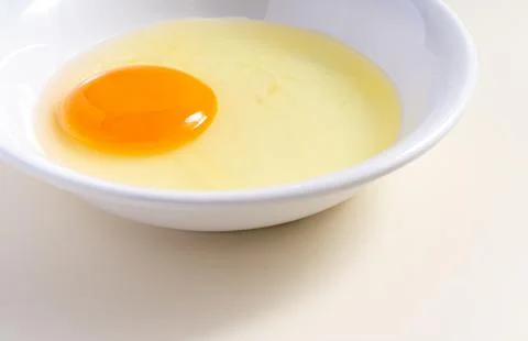 Raw eggs. Close up. flat lay raw eggs yolk in bowl. Isolated broken white b.. Stock Photos