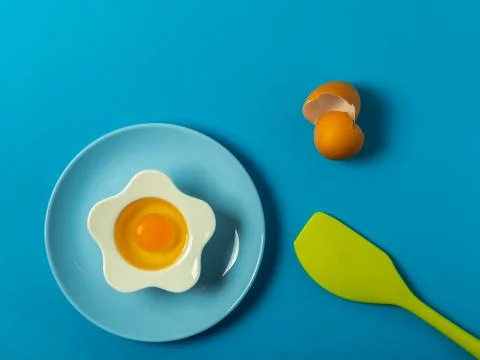 Raw eggs on a solid blue color background Stock Photos