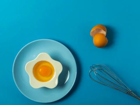 Raw eggs on a solid blue color background Stock Photos