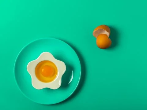 Raw eggs on a solid green color background Stock Photos