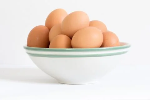 Raw eggs in white bowl Stock Photos