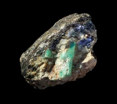 Raw emerald gemstone crystals inside feldspar rock with molybdenite, mica and Stock Photos