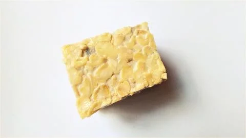 A raw fermented plant based block with visible beans and creamy texture sits  Stock Photos