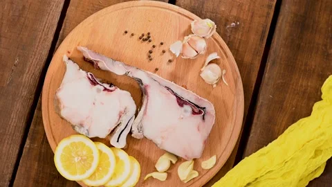 Raw fish cod on a tray, lemon tomato and pepper, wooden table in rustic style 스톡 동영상 194039135