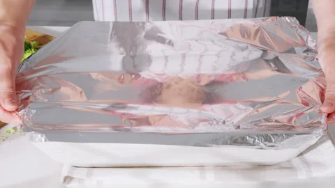 Raw fish fillets and garlic cloves placed on a white plate and wooden board. Stock Footage 308179412