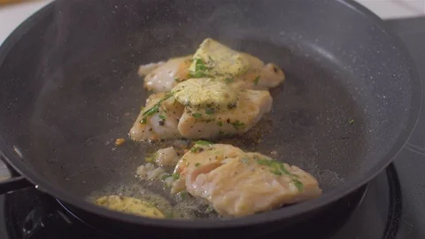 Raw fish fillets fried in a pan with butter Video stock 111968982
