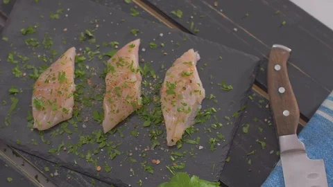 Raw fish fillets with spices on black stone Video stock 111970258