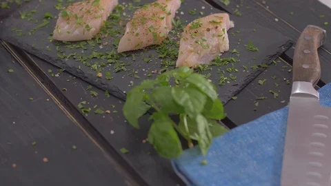 Raw fish fillets with spices on black stone Stock Footage 111970356