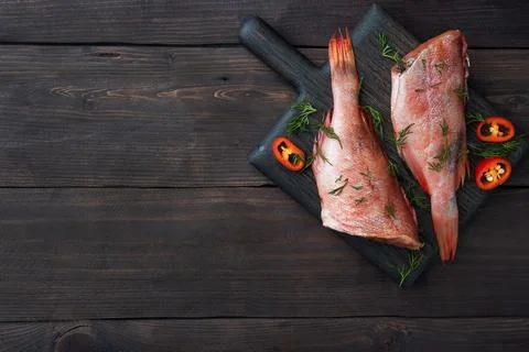 Raw fish perch without a head with lemon slices and dill greens and red chi.. Stock Photos